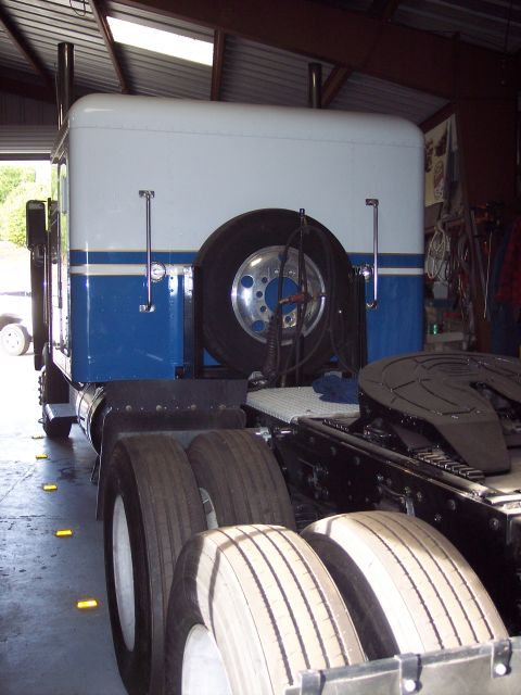1981 Kenworth W900A - Rear view of a semi-truck showing its dual rear wheels and mounted spare tire.