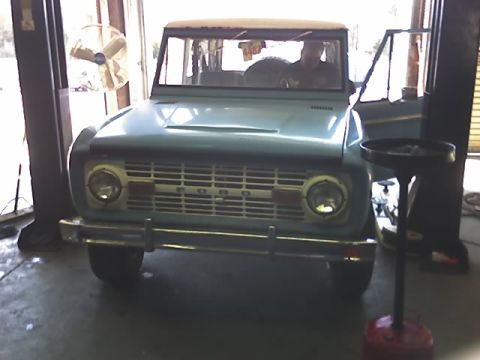 1996 Ford Bronco - This classic Ford Bronco is parked inside a garage, possibly undergoing maintenance.