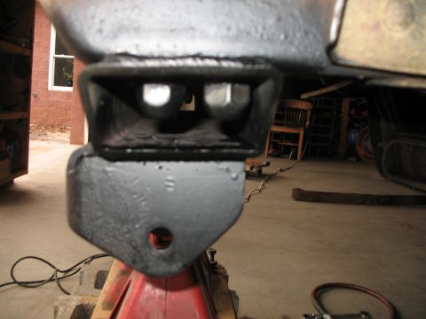 1985 Ford Bronco - A vehicle part, likely from the suspension, is shown supported by a jack stand in a garage setting.