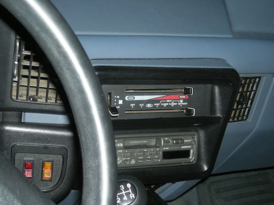 Interior dashboard with steering wheel, climate controls, and radio. Blue dashboard panels