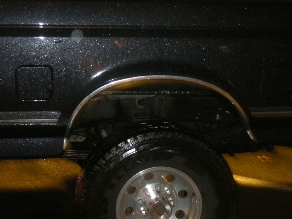 1991 Ford Bronco rear wheel well with chrome trim and leaf springs visible