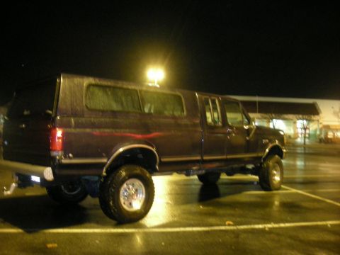 1991 Ford Bronco - This lifted Ford F-Series truck is equipped with a camper shell and large off-road tires.