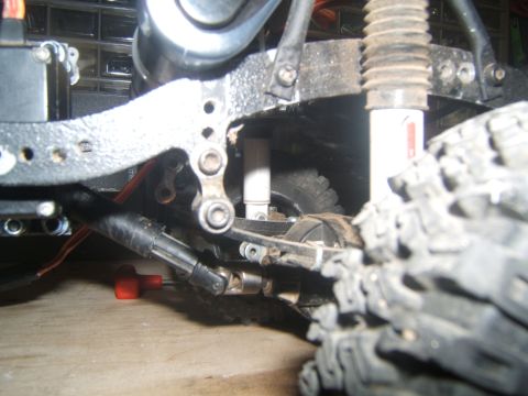 1988 Ford Bronco - Detail shot of the undercarriage of a remote-controlled crawler vehicle, showing suspension and drive shafts.