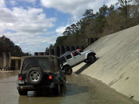 2008 Jeep Wrangler - Two Jeep Wranglers navigate an off-road course with water and a steep concrete incline.