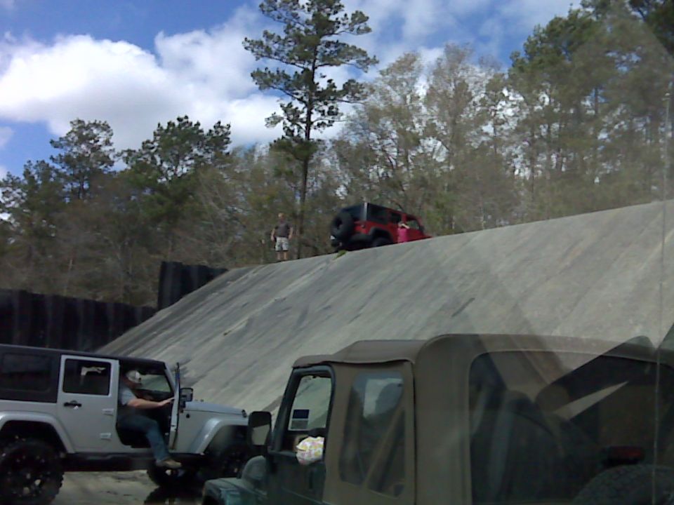 Silver 2008 Jeep Wrangler with driver door open, another red Jeep on hill