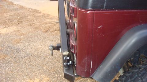 1995 Ford Bronco - Rear view of a red SUV showing a spare tire carrier and tow hitch, with visible scratches on the body panel.