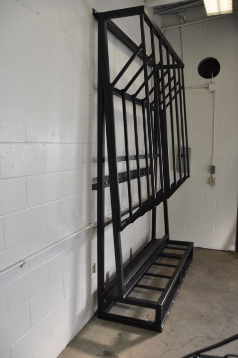 1996 Ford Bronco - A black metal rack, likely for storage or display, is positioned against a white cinder block wall.