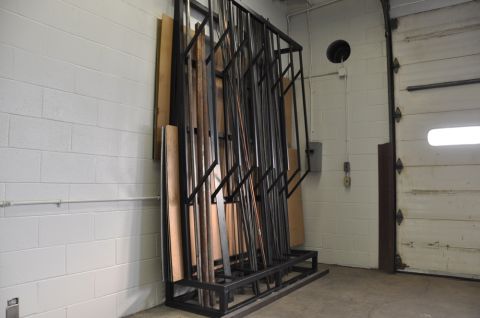 1996 Ford Bronco - A metal rack stores various lengths of metal and wood stock in a workshop or garage setting.