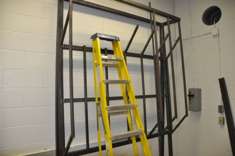 1996 Ford Bronco - Workshop scene with a metal frame and a yellow ladder. No vehicle is present.