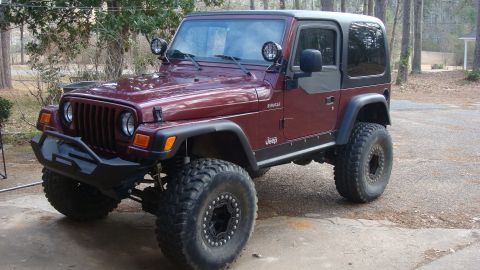 1995 Ford Bronco - This modified Jeep Wrangler sits parked outdoors on a paved surface.