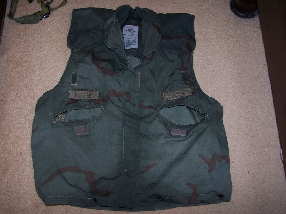 Camouflage vest with pockets and straps on carpet