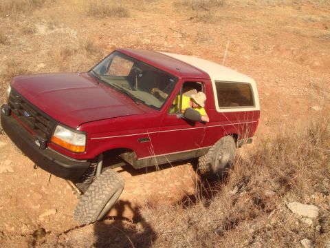 1992 Ford Bronco - 1992 Ford Bronco navigating rough terrain with one wheel off the ground.