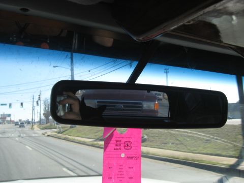 1988 Ford C-350 (Centurion Conversions) - Reflection of a red truck's grille is visible in the rearview mirror, with a pink tag hanging below.
