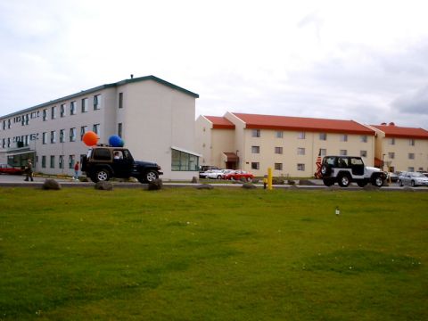 1996 Ford Bronco - A dark Jeep Wrangler with balloons on its roof is parked in front of a hotel, with other vehicles nearby.