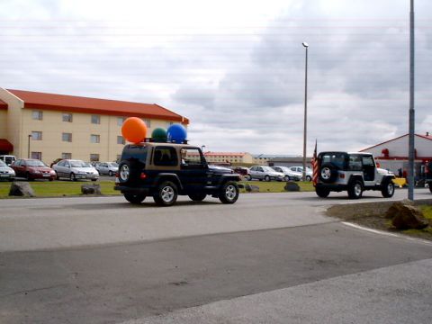 1996 Ford Bronco - Two Jeeps drive on a road; one is decorated with balloons.