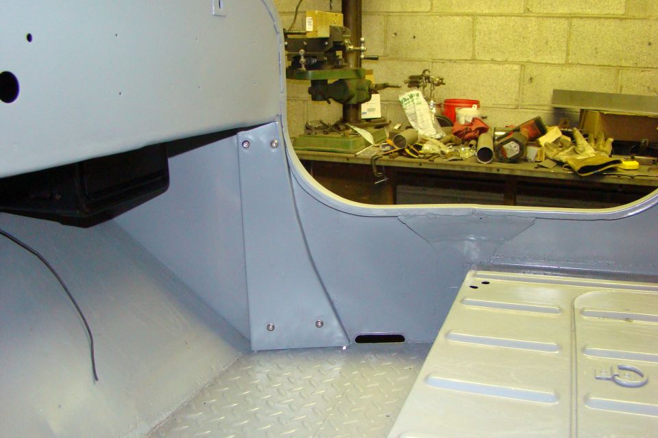 Gray painted interior of a Jeep CJ 2A showing the floor pan and firewall.