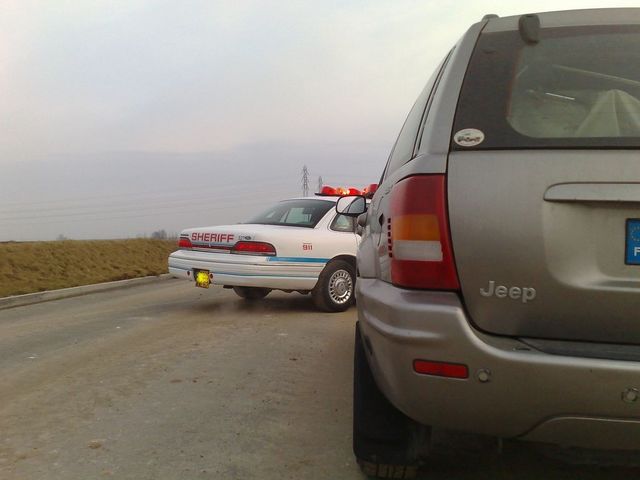 Photo of a Jeep Grand Cherokee parked behind a sheriff police sedan