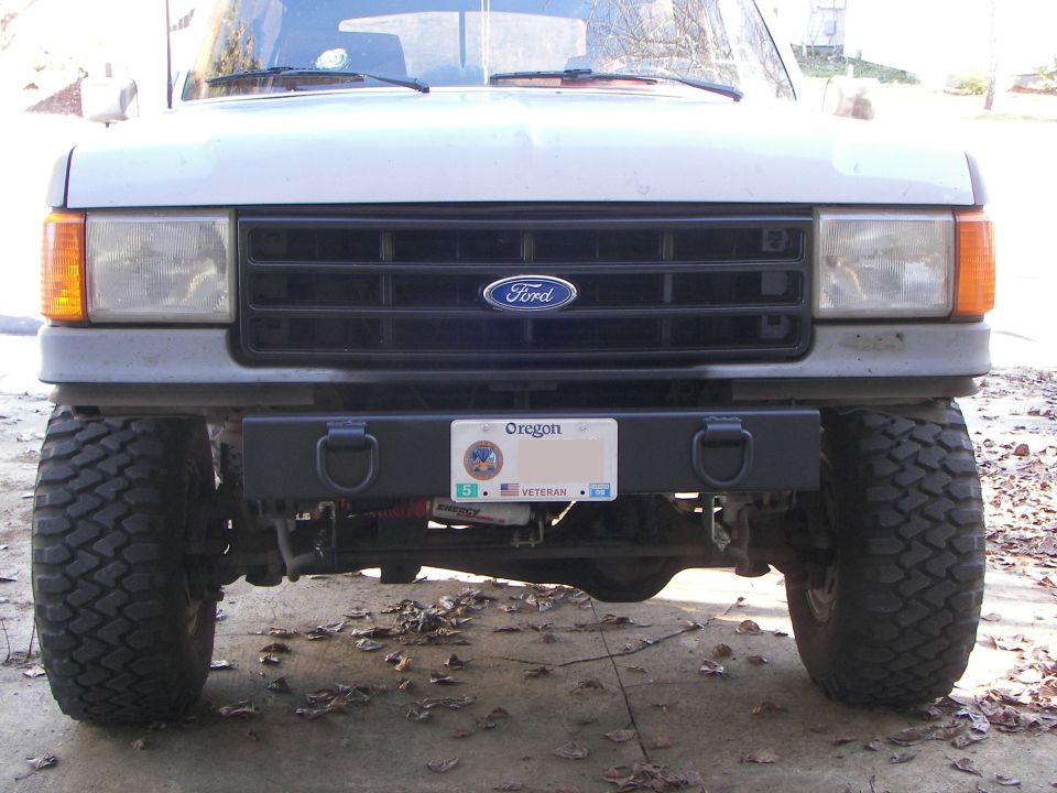 Front view of lifted gray Ford Bronco with black aftermarket bumper, tow shackles and Oregon plate