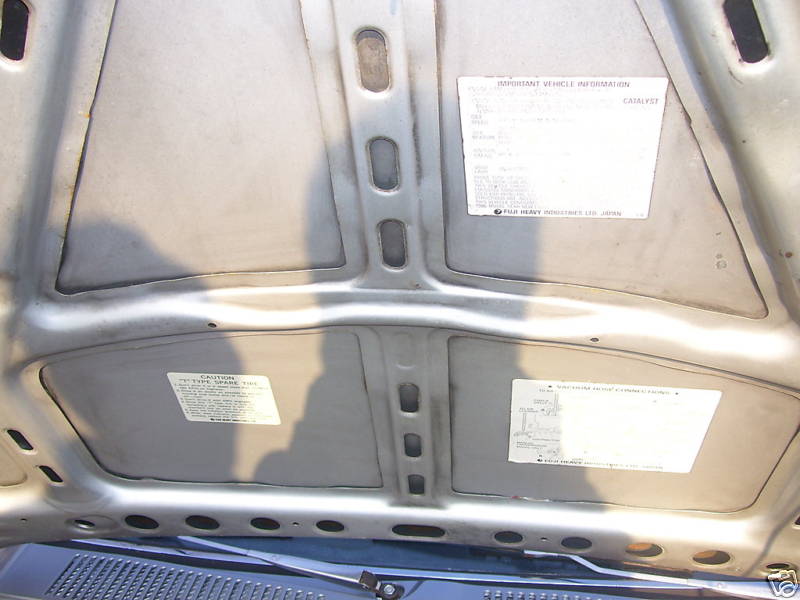 Underside of a Subaru Brat hood with two stickers.