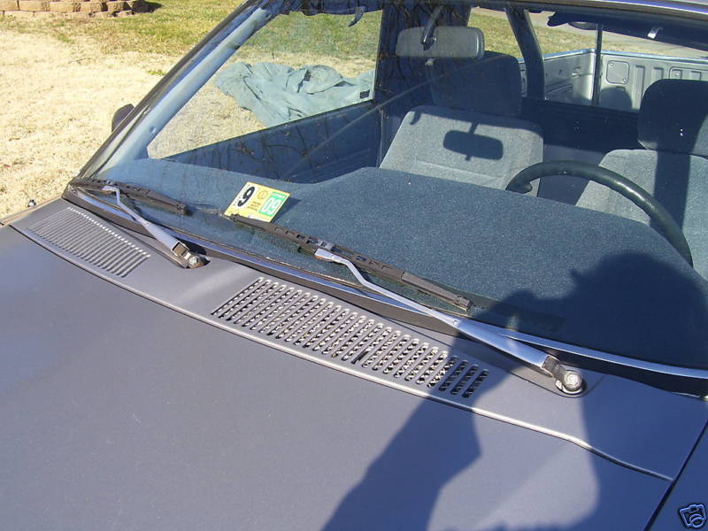 Gray vehicle hood and windshield with inspection sticker.