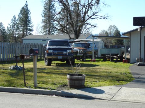 1991 Ford Bronco - A black 1991 Ford Bronco is parked in a grassy yard next to a rusty mailbox and a brown pickup truck. A light blue trailer is parked under…