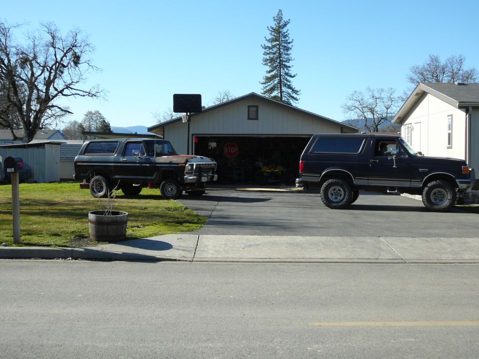 Two Ford Broncos parked in a driveway.