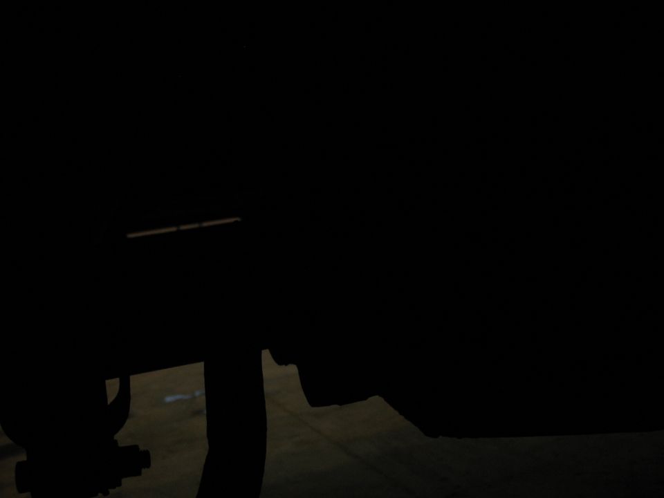 Silhouette of vehicle undercarriage with tire and suspension parts visible.