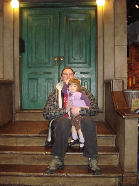 2000 Ford Crown Victoria - A man sits on steps in front of a green double door holding a young child on his lap. The child is wearing a purple shirt and polka dot pan…