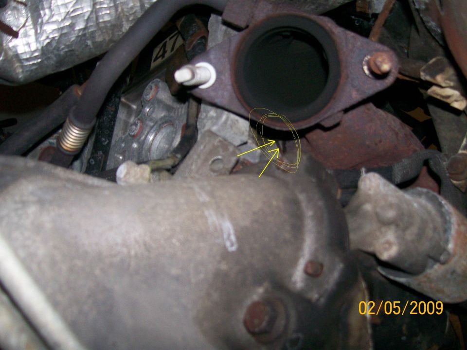 Engine exhaust manifold connection with highlighted area and date stamp.