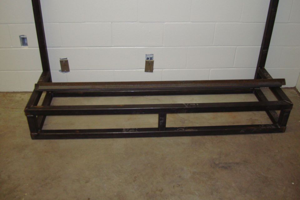 Welded steel base rail of a frame fixture on a shop floor