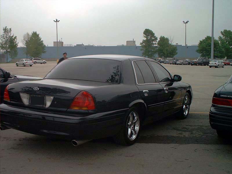 Black 2000 Ford Crown Victoria parked in a lot, rear view