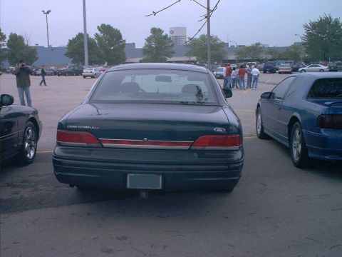 2000 Ford Crown Victoria - Rear view of a Ford Crown Victoria LX sedan parked in a lot with other vehicles.