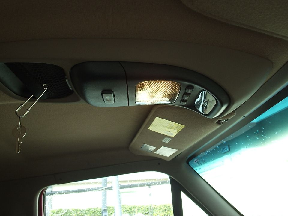 Interior overhead console with dome light, buttons, visor mirror, and keys hanging from speaker grille.
