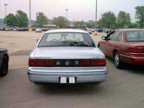 2000 Ford Crown Victoria - A silver 1998 Mercury Grand Marquis LS is seen from the rear, parked beside a red sedan in a parking lot.