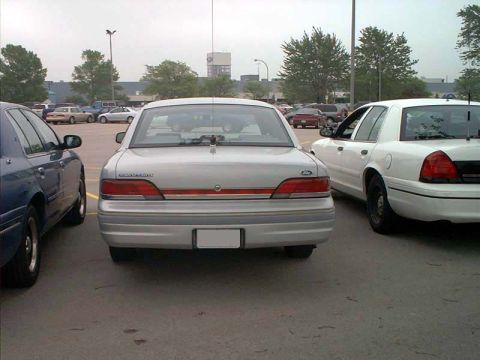 2000 Ford Crown Victoria - Rear view of a silver 2000 Ford Crown Victoria parked in a lot.