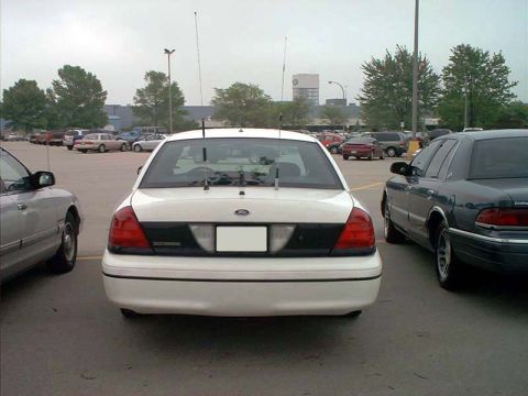 2000 Ford Crown Victoria - Rear view of a white 2000 Ford Crown Victoria parked in a lot with other vehicles.