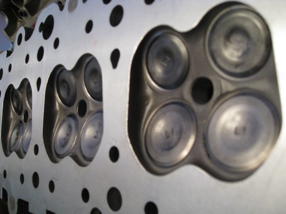 Close-up of engine cylinder head combustion chambers and valves.
