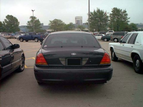 2000 Ford Crown Victoria - This black Ford Crown Victoria is parked in a lot with other vehicles visible.