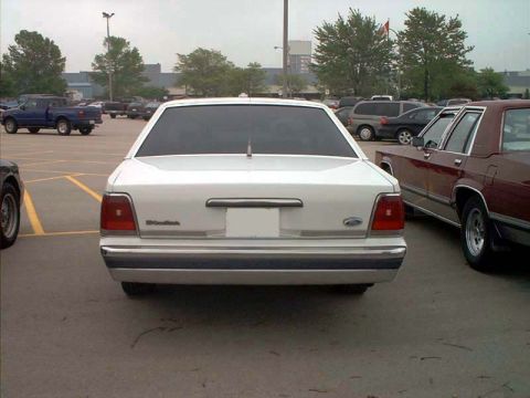 2000 Ford Crown Victoria - Rear view of a white 2000 Ford Crown Victoria parked in a lot with other vehicles.