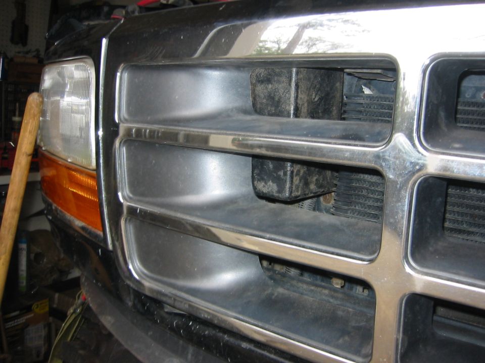 Front grille and headlight of a black Ford Bronco.