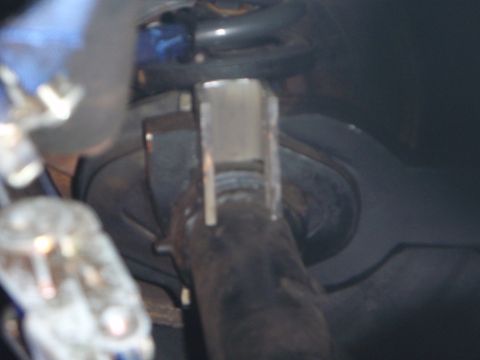 1996 Ford Bronco - This is a close-up, low-angle shot of a metal part, possibly a bracket or mount, attached to a dark, cylindrical component. The part appear…