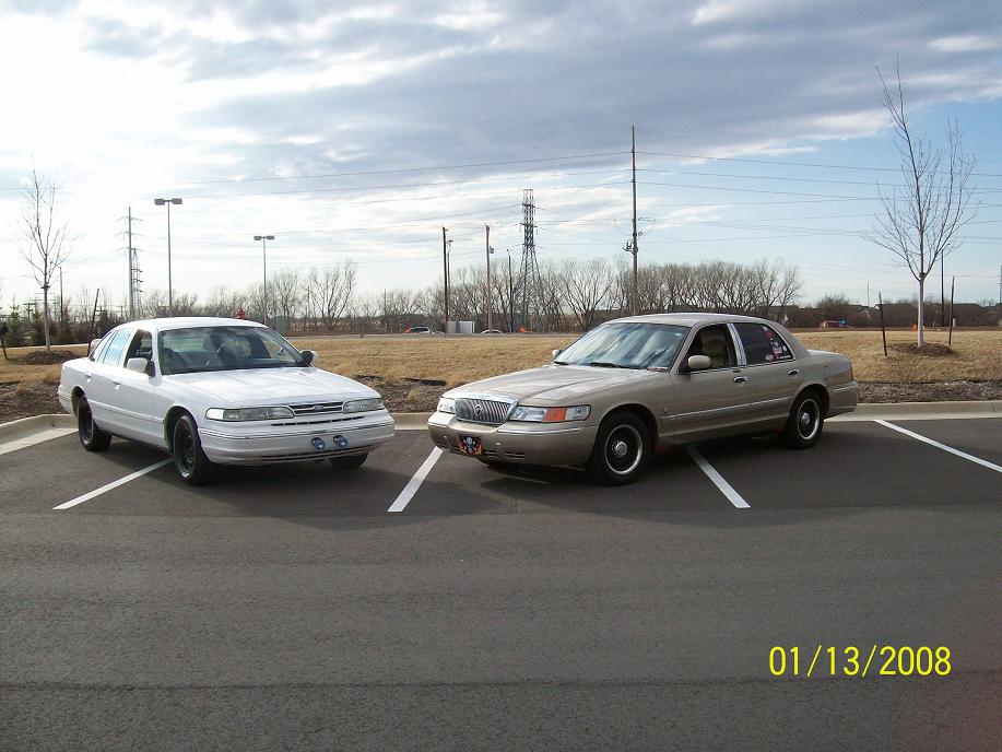 Photo of a white Crown Victoria and tan Grand Marquis parked side by side