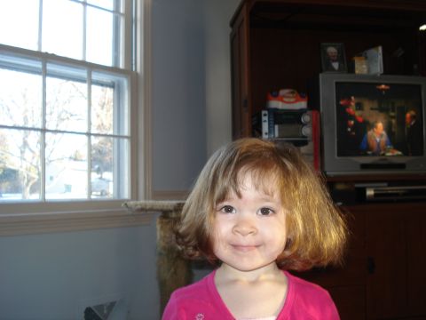 2000 Ford Crown Victoria - A young child smiles for the camera in a room with a window and a television.