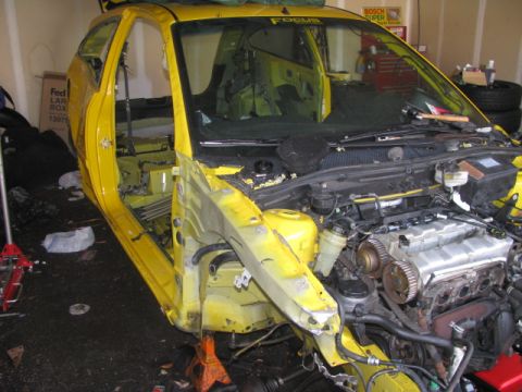2003 Ford Focus - Disassembled 2003 Ford Focus in a garage, engine exposed, body panels removed.