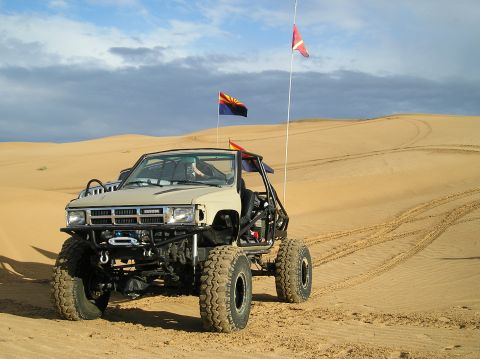 1986 Toyota Hilux - This heavily modified Toyota pickup truck is equipped for off-road dune riding, a roll cage and large tires.