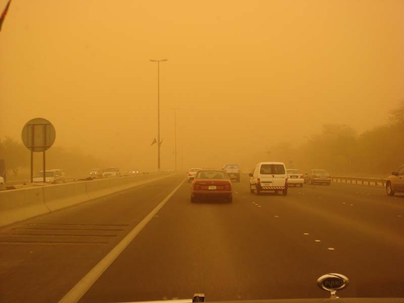 Highway traffic obscured by a severe sandstorm, visibility is extremely low