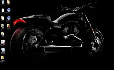 1990 Ford Bronco - A black motorcycle is parked in front of a black background. The motorcycle is viewed from the side, with a focus on the rear wheel and exh…