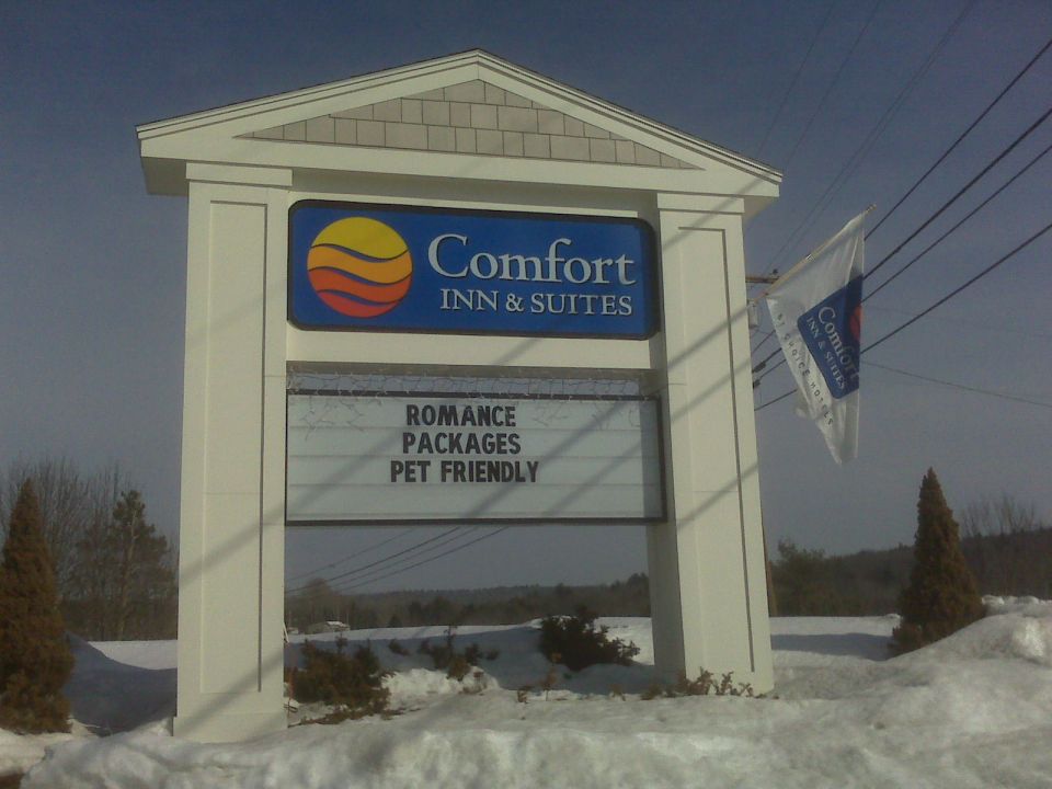 Comfort Inn & Suites sign with "ROMANCE PACKAGES PET FRIENDLY" and a hotel flag.