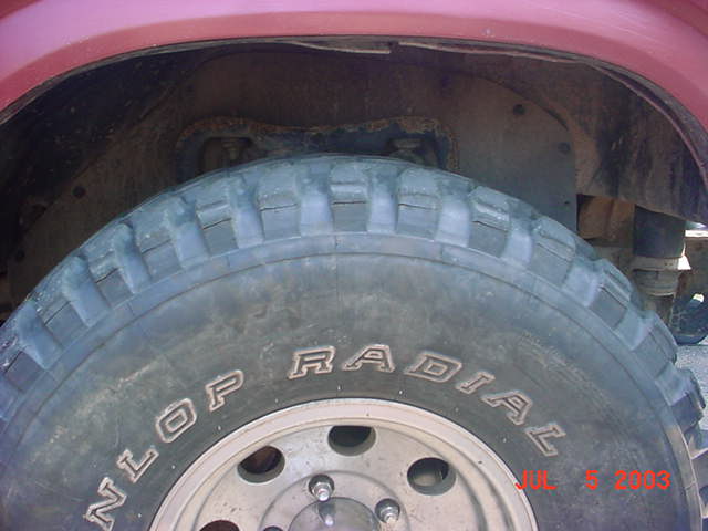 Dunlop Radial off-road tire on silver alloy wheel in red vehicle's wheel well