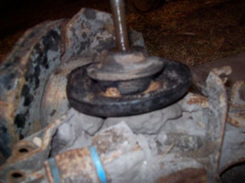 1986 Ford Bronco - A close-up, low-angle shot shows a heavily rusted suspension component, possibly a shock mount or spring perch, from a vintage vehicle. The…